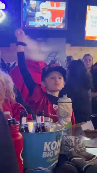 Young fan cheering in Texans gear at watch party